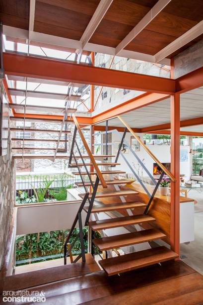 Aberto no meio da casa, o vão envidraçado entre os andares orienta a circulação e permite a multiplicação da claridade. O esqueleto metálico e as pisadas de madeira fazem da escada um elemento leve, quase escultural. Aberto no meio da casa, o vão envidraçado entre os andares orienta a circulação e permite a multiplicação da claridade. O esqueleto metálico e as pisadas de madeira fazem da escada um elemento leve, quase escultural.