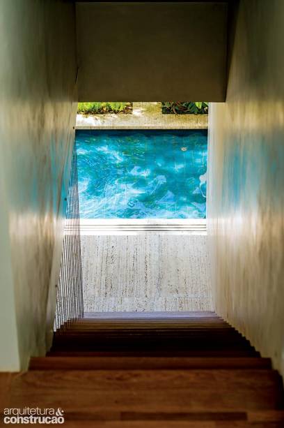 A escada de madeira foi poupada na reforma, mas ganhou um toque charmoso: quem a desce depara com este visual. “Incluímos água na frente e nos fundos, para dar a sensação de que a casa está flutuando”, explica a arquiteta.