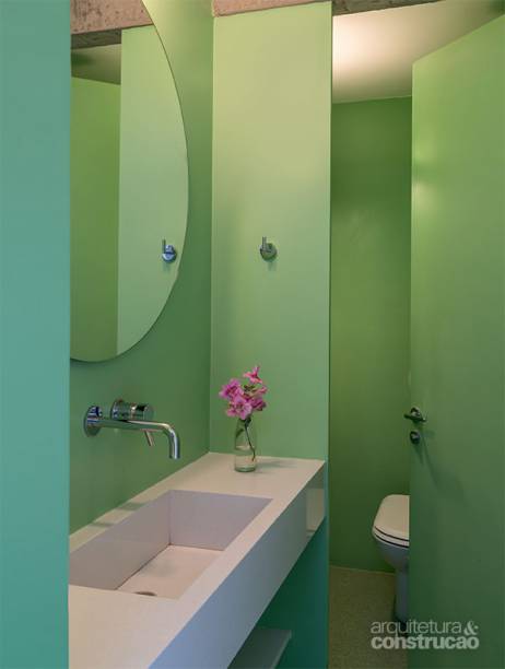 Cada ambiente molhado deste apartamento recebeu uma tonalidade: no lavabo, nuances esverdeadas cobrem tanto o piso de rocha sintética (Silestone) quanto as paredes e a divisória de compensado naval, todas pintadas de tinta epóxi. “O reboco precisa estar perfeito para um visual uniforme”, recomenda Sarkis Semerdjian, do escritório Pascali Semerdjian Arquitetos.