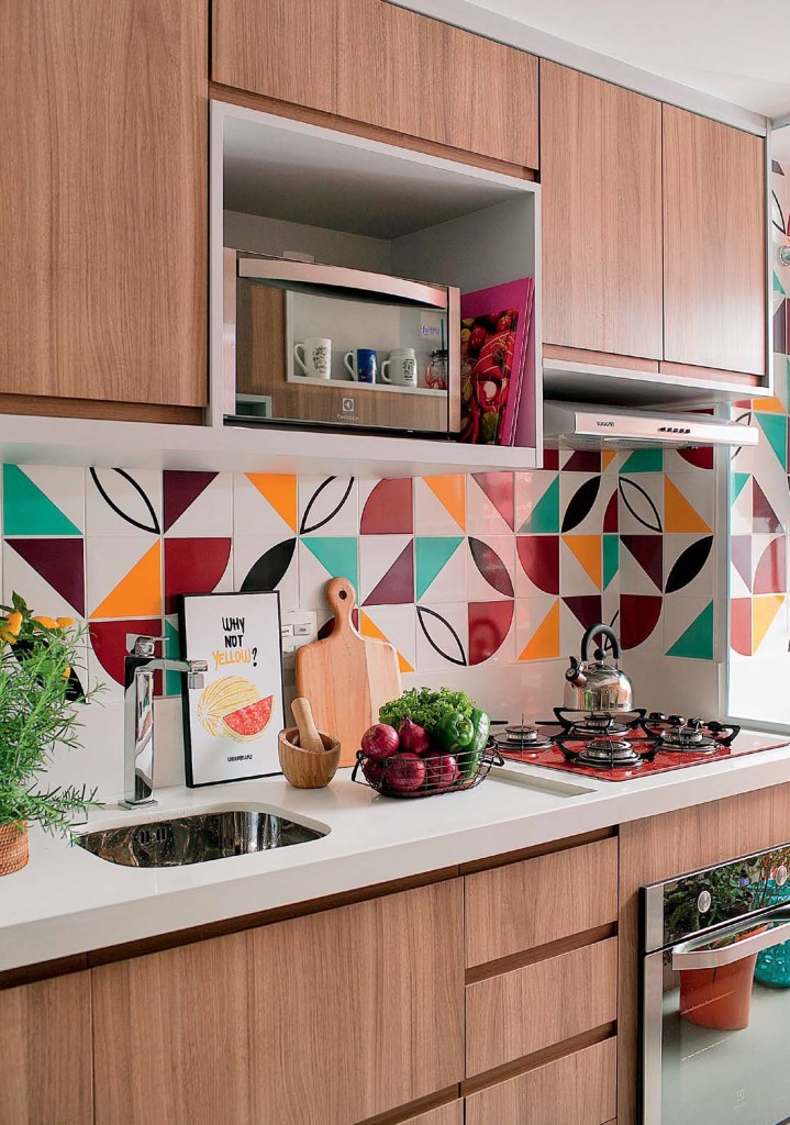 Cozinha com bancada branca e azulejos coloridos