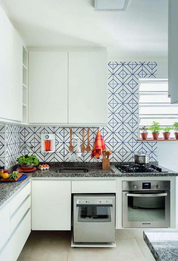 Cozinha com armários brancos e azulejos azuis e brancos