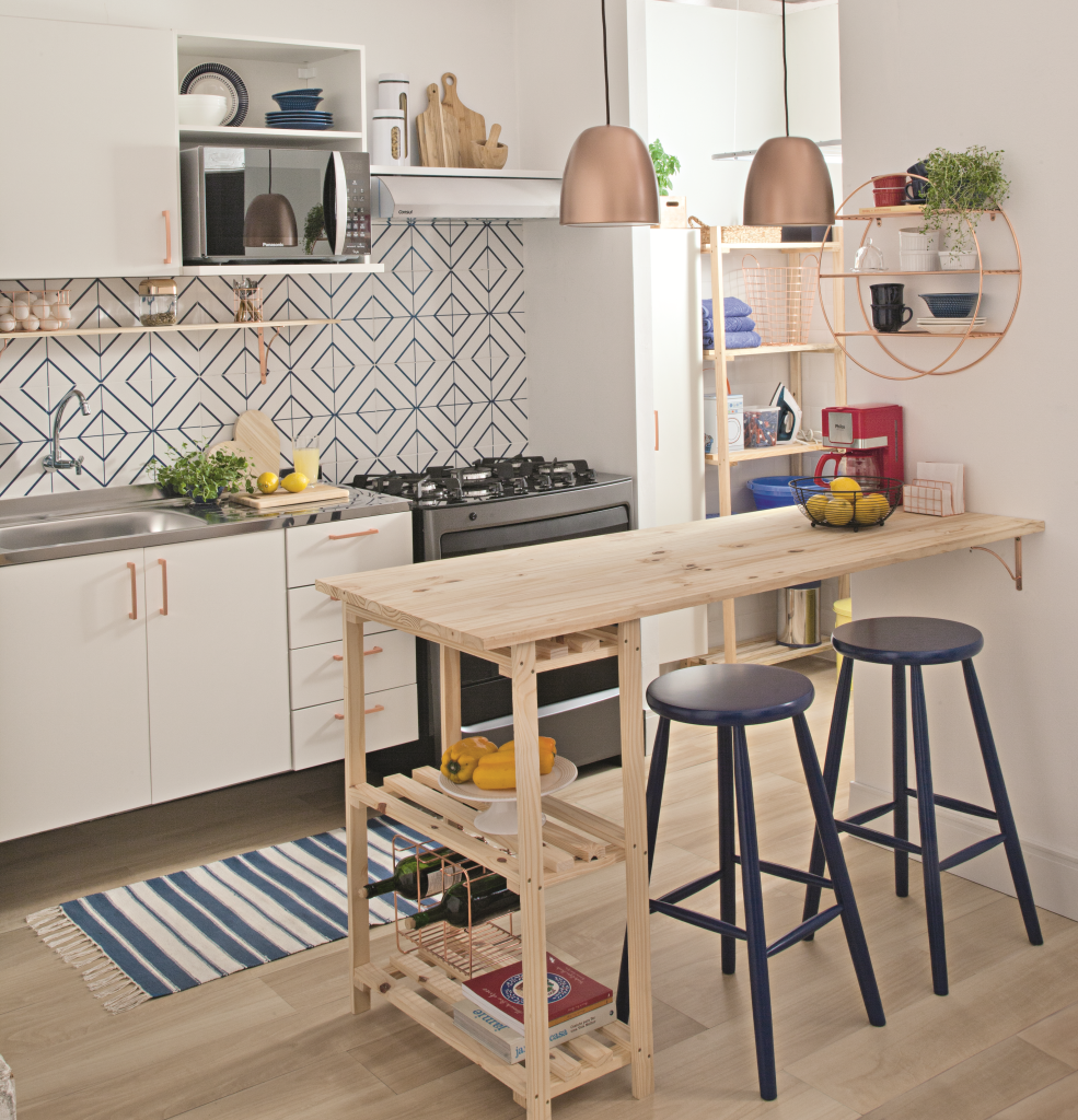 Cozinha integrada com mesa de madeira e azulejos brancos e azuis.
