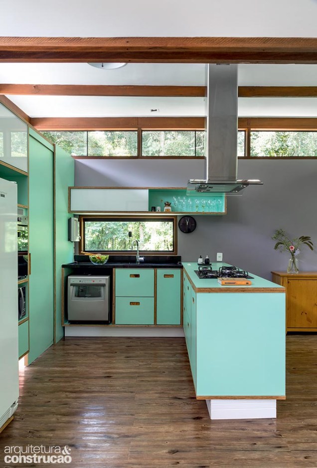 Os armários da cozinha levam agradável tom verde no laminado que finaliza o compensado. Entre os revestimentos, imperam aqueles fáceis de cuidar, como o piso vinílico da Tarkett e a pintura, cuja cor suja menos do que o branco.