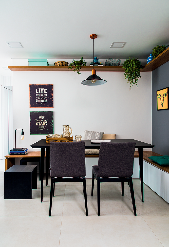Sala de jantar em residência pequena, com um armário suspenso coberto de plantas.
