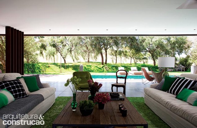 A sala de estar se mostra totalmente aberta para a piscina. No canto da foto, à esq., colunas metálicas reforçaram a sustentação do grande vão. A sala de estar se mostra totalmente aberta para a piscina. No canto da foto, à esq., colunas metálicas reforçaram a sustentação do grande vão.