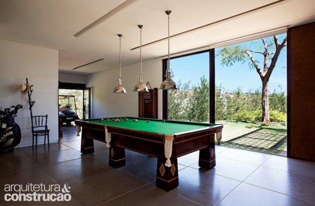 Pensado para o proprietário, este canto reúne seus hobbies – o ponto para estacionar o carrinho de golfe e a mesa de bilhar. Pensado para o proprietário, este canto reúne seus hobbies – o ponto para estacionar o carrinho de golfe e a mesa de bilhar.