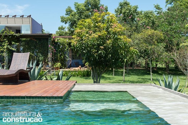 Revestida de pastilha de vidro reciclado da Vidro Real (verde floresta, ref. N22), a piscina reforça a ligação visual com o jardim.