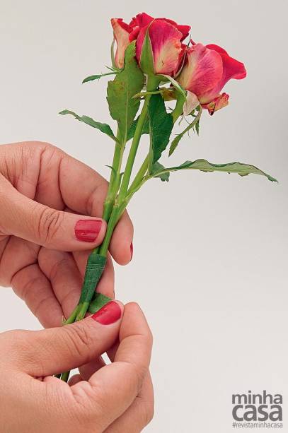 1. Reúna três flores da mesma espécie e as amarre com fita floral, fazendo pequenos buquês – repita o processo com todas as flores e com as sementes, formando macinhos. Atenção: é importante igualar as alturas. Para prolongar caules curtos, use as hastes descartadas de outras flores, unindo-as com a fita floral.