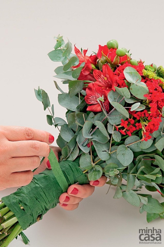 3. Depois de juntar os maços, prenda os ramos de eucalipto ao redor das flores e passe a fita envolvendo o conjunto. 3. Depois de juntar os maços, prenda os ramos de eucalipto ao redor das flores e passe a fita envolvendo o conjunto.