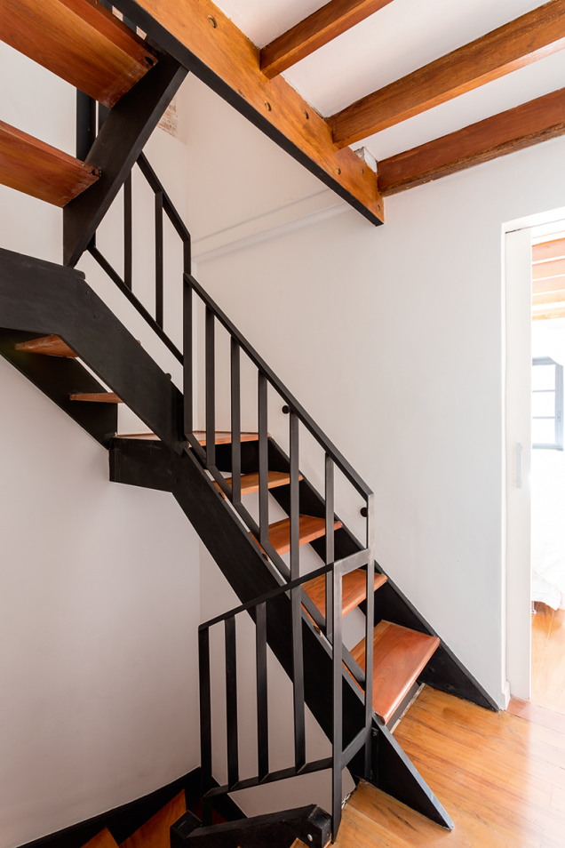O guarda-corpo de ferro projetado pelos arquitetos se somou à escada existente, que conduz ao sótão. No piso, o assoalho original foi lixado e recebeu aplicação de resina Bona. O guarda-corpo de ferro projetado pelos arquitetos se somou à escada existente, que conduz ao sótão. No piso, o assoalho original foi lixado e recebeu aplicação de resina Bona.
