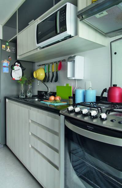 <span>Apenas um lado do ambiente recebeu marcenaria, tendo em vista a melhor área de circulação. As portas dos módulos superiores, de vidro preto, dão charme aos móveis de madeira clarinha. Projeto do arquiteto André Bove.</span> <span>Apenas um lado do ambiente recebeu marcenaria, tendo em vista a melhor área de circulação. As portas dos módulos superiores, de vidro preto, dão charme aos móveis de madeira clarinha. Projeto do arquiteto André Bove.</span>