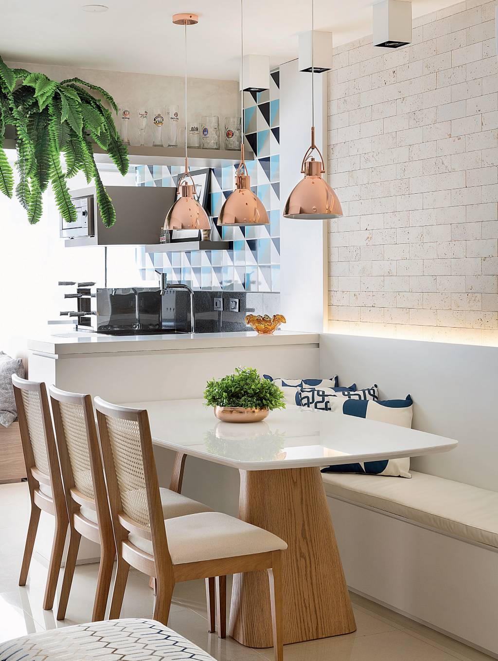 O capricho com os acabamentos n&atilde;o passa despercebido! A maior superf&iacute;cie da sala, que emoldura tanto a mesa de jantar quanto o painel da TV, recebeu charmosos tijolinhos de travertino (Anat&oacute;lia Bruto Tradicional, 20,3 x 7,5 cm. Palimanan). Projeto Elen Saravalli.