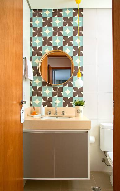 Para atuar como lavabo, este banheiro se encheu de graça com o pendente amarelo Dot Color, da Taschibra (Mobly), e os adesivos coloridos na parede acima da bancada (modelo similar: Geométrico, Cola Comigo). Para atuar como lavabo, este banheiro se encheu de graça com o pendente amarelo Dot Color, da Taschibra (Mobly), e os adesivos coloridos na parede acima da bancada (modelo similar: Geométrico, Cola Comigo).