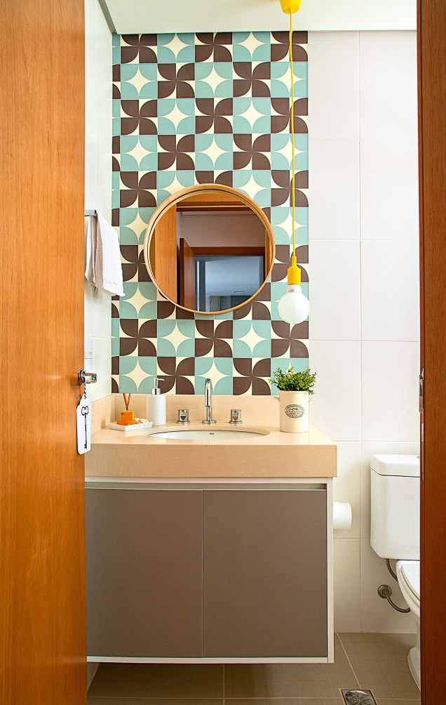 Para atuar como lavabo, este banheiro se encheu de graça com o pendente amarelo Dot Color, da Taschibra (Mobly), e os adesivos coloridos na parede acima da bancada (modelo similar: Geométrico, Cola Comigo).