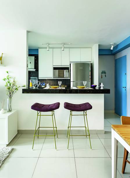 <span>O imóvel foi entregue com a cozinha fechada. “Pequena, ela ficava enclausurada e escura, pois a única janela era a da lavanderia”, relata Juliana. A saída foi quebrar uma parede e instalar um balcão de granito – verde-ubatuba, o mesmo da pia - unindo os ambientes e ganhando boa área de apoio. As banquetas altas com assento roxo e pés verdes dão o toque de graça (Bienal, Fernando Jaeger). Projeto da arquiteta Juliana Shwartzbaum.</span> <span>O imóvel foi entregue com a cozinha fechada. “Pequena, ela ficava enclausurada e escura, pois a única janela era a da lavanderia”, relata Juliana. A saída foi quebrar uma parede e instalar um balcão de granito – verde-ubatuba, o mesmo da pia - unindo os ambientes e ganhando boa área de apoio. As banquetas altas com assento roxo e pés verdes dão o toque de graça (Bienal, Fernando Jaeger). Projeto da arquiteta Juliana Shwartzbaum.</span>