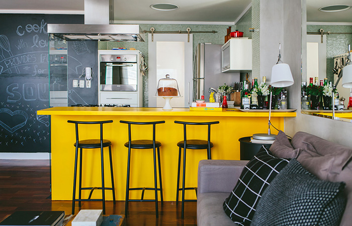 Loft moderno com paredes de cimento queimado e muito amarelo