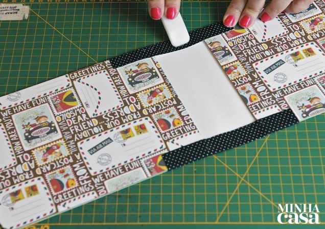 5. Vire as margens de cartolina de 2,5 cm e fixe-as também. Se preferir, use uma dobradeira para prender melhor.