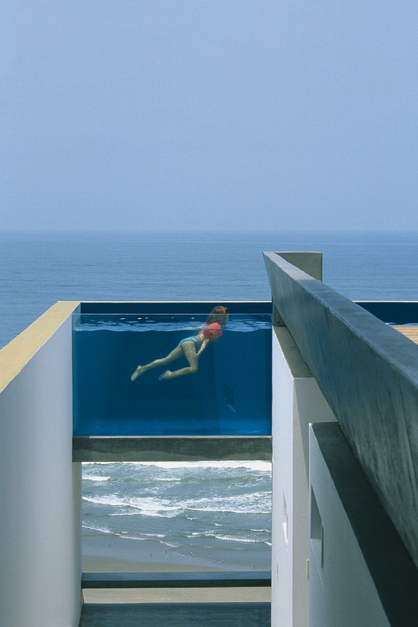 Nesta casa em Cañete, no Peru, a piscina de vidro elevada parece se misturar ao mar. Projeto do escritório Barclay & Crousse.