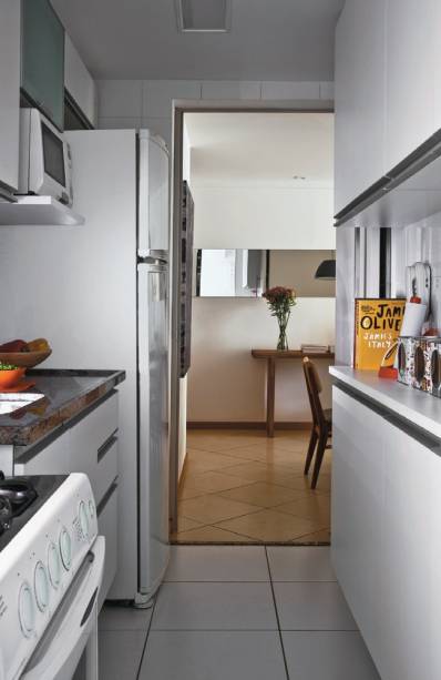 <span>Móveis ao longo de todo o ambiente tiram proveito da área estreita. “Para conseguir uma circulação confortável, de 80 cm, o armário em frente à pia tem apenas 25 cm de profundidade, o ideal para copos e itens pequenos”, explica a arquiteta Cristiane Passos.</span> <span>Móveis ao longo de todo o ambiente tiram proveito da área estreita. “Para conseguir uma circulação confortável, de 80 cm, o armário em frente à pia tem apenas 25 cm de profundidade, o ideal para copos e itens pequenos”, explica a arquiteta Cristiane Passos.</span>