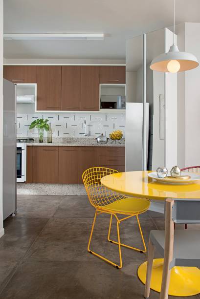 Neste apartamento assinado por Gabriel, a cozinha vista da sala ganhou azulejos da Lurca. No piso, cimento queimado.