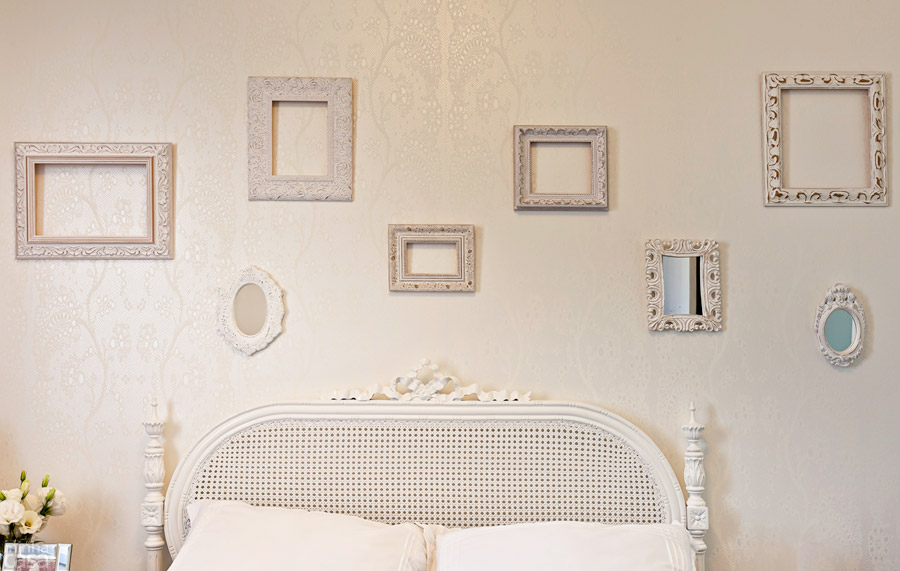 Para a parede atrás da cama, Elvira elegeu um papel de parede texturizado. “Embora a superfície tenha ficado vazia demais, resisti à ideia de agregar cor pendurando quadros, por exemplo”, explica a designer Elvira Monteiro. A solução foi montar uma composição de molduras vazadas, que inclui um espelhinho. Para a parede atrás da cama, Elvira elegeu um papel de parede texturizado. “Embora a superfície tenha ficado vazia demais, resisti à ideia de agregar cor pendurando quadros, por exemplo”, explica a designer Elvira Monteiro. A solução foi montar uma composição de molduras vazadas, que inclui um espelhinho.