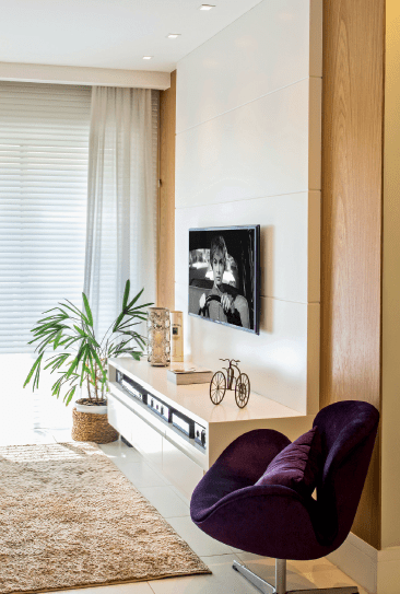 No apê de 58 m² da médica Gisele Mattioli, o foco era driblar a metragem escassa e proporcionar a sensação de amplitude. Para tanto, na sala, as arquitetas cariocas Elise e Evelyn Drummond desenharam um painel com rack suspenso, que deixa o piso à mostra. Tudo foi executado com MDF (Marcenaria DS Móveis, R$ 5 520), mas é a combinação de acabamentos que garante o charme do conjunto: enquanto os elementos centrais (1,40 x 0,40 x 2,40 m) foram laqueados de branco, os trechos laterais (0,40 x 0,10 cm x 2,40 m cada) ganharam laminado melamínico em um padrão de madeira, que ajuda a aquecer o visual do ambiente. Logo acima, lâmpadas dicroicas embutidas no forro de gesso oferecem uma iluminação dirigida, que ressalta o conjunto e ajuda a compor um clima intimista.