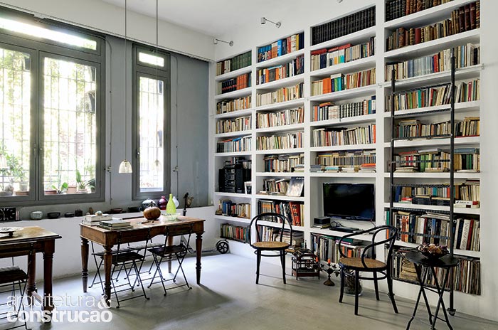 As janelas originais da construção fornecem luz natural à biblioteca, cuja estante de gesso abriga muitos livros, o som e a TV. As janelas originais da construção fornecem luz natural à biblioteca, cuja estante de gesso abriga muitos livros, o som e a TV.