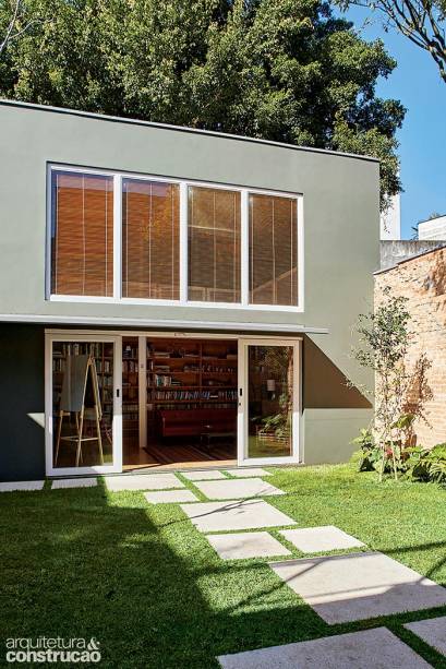 A edícula funciona como escritório à frente do jardim, cujas pisadas alternam placas de 60 x 60 cm e de 1 x 1 m de um revestimento sustentável que recicla materiais como entulho, cacos de vidro, resíduos de marmoraria e pneus (Concresteel).