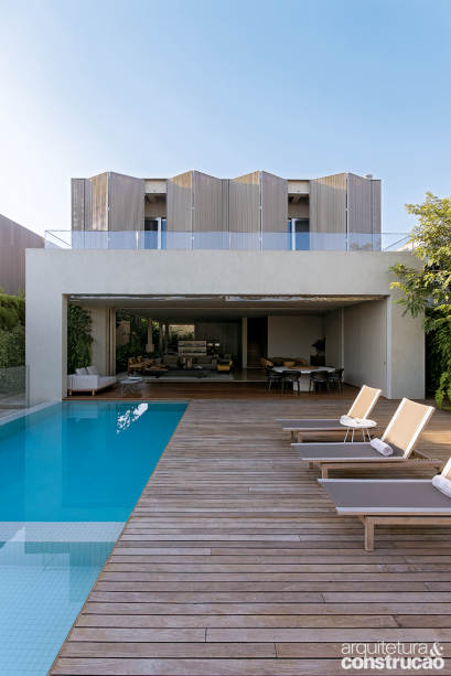 A ideia de erguer os ambientes sociais resultou nesta prazerosa área integrada, contendo piscina, varanda, sala e home theater. O pórtico com 10 m de largura marca a fachada.