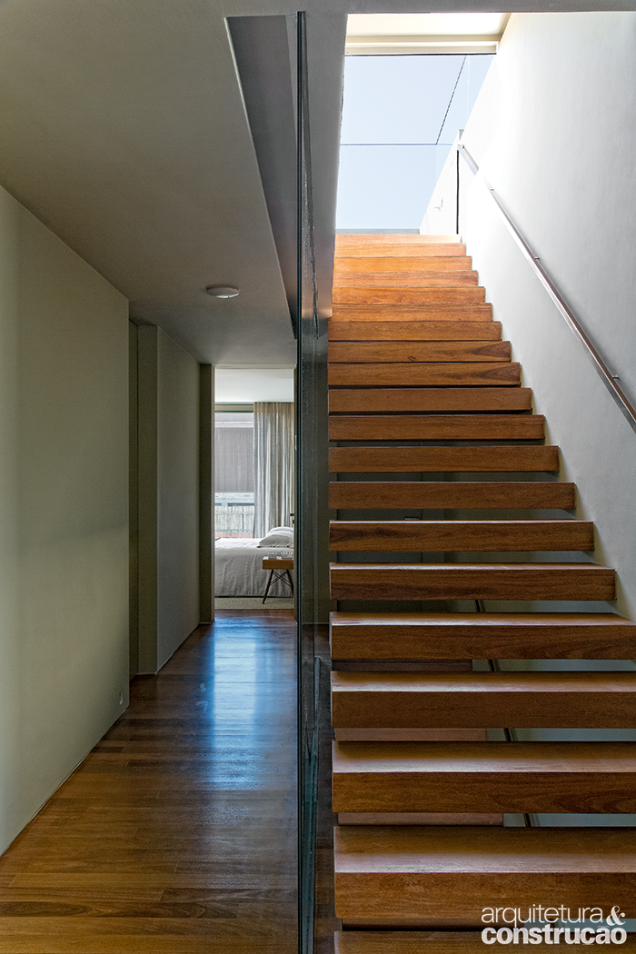 Para maior aconchego, as áreas íntimas contam com tacos de cumaru, material presente também nas escadas (esta conduz ao solário, no topo da construção).