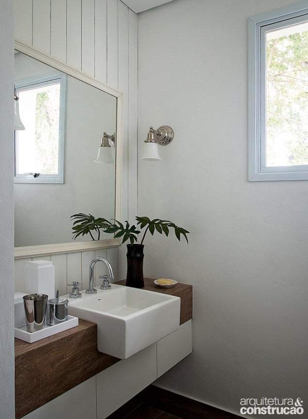 No banheiro, lambris nas paredes reforçam o estilo campestre.