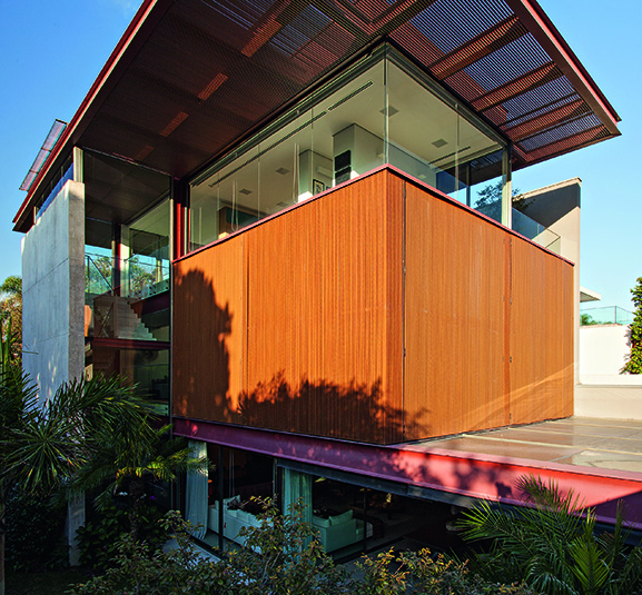 A porção coberta do nível mais alto da construção inclui uma sala de estar, copa, lavabo e spa (resguardado pelos painéis de madeira vistos na imagem acima). Na outra ponta, estão a varanda e a piscina