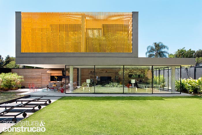 Residência com brises metálicos integrada ao jardim
