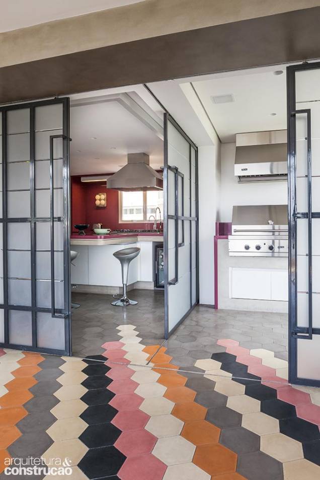 O jogo de portas de perfis de ferro e vidro acidato cerca a cozinha e o espaço gourmet ao lado dela. É possível abrir todas e obter uma só área, conectada à sala e à varanda. O jogo de portas de perfis de ferro e vidro acidato cerca a cozinha e o espaço gourmet ao lado dela. É possível abrir todas e obter uma só área, conectada à sala e à varanda.