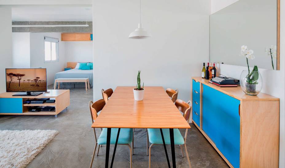 Às referências monocromáticas trazidas pelo morador, os arquitetos acrescentaram um toque brasileiro de cor: o mobiliário de compensado, desenhado por eles e executado pela Maria Joaquina Marcenaria, tem trechos de laminado Azul Mediterrâneo (Formica) – caso do bufê. Projeto MarcoZero Estudio.