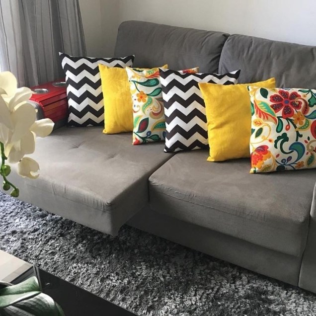 Outra sala com sofá cinza. Desta vez é da @silvafrancianne, que optou por personalizar o espaço com almofadas estampadas nas cores preto, amarelo e branco.
