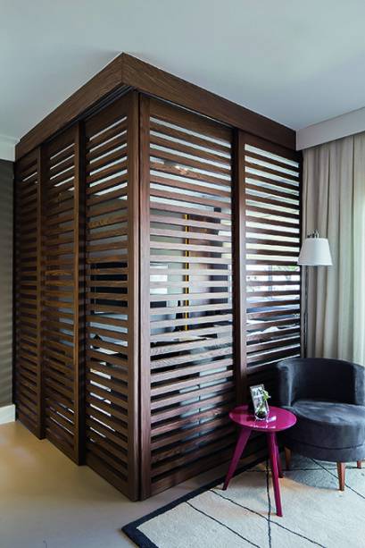 Para dividir sem isolar o home theater, o escritório Sesso & Dalanezi Arquitetura intercalou folhas móveis e fixas (0,60 x 2,30 m cada uma). “Vazadas, as peças de nogueira permitem leve integração mesmo quando fechadas”, fala o arquiteto Marcello Sesso. Execução da Marcenaria Madeira Nobre.