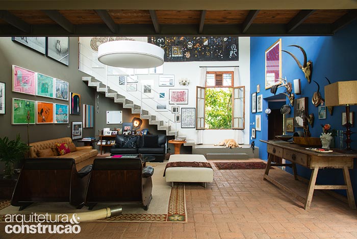 O azul colore a parede da sala por onde se dá a entrada. A janela de demolição evoca as construções rurais, bem como o piso de tijolo, escolha surpreendente para os ambientes internos do térreo. O toque contemporâneo vem da escada de concreto.