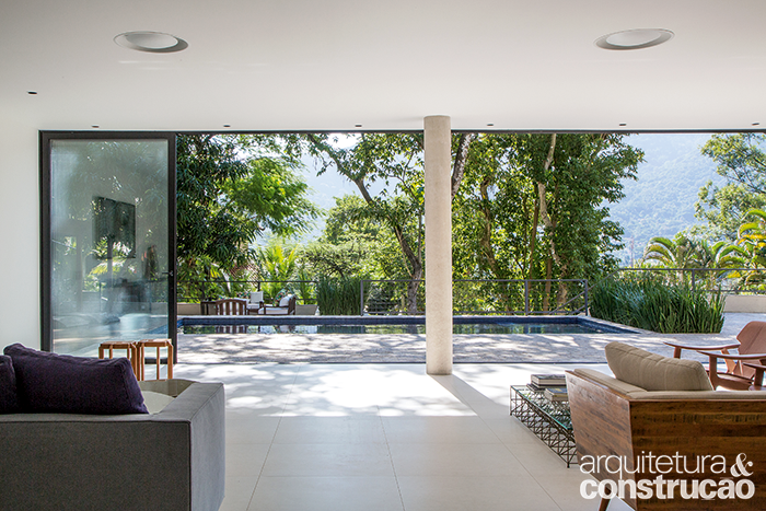 A sala de estar tornou-se um delicioso e amplo belvedere, repare na vista à frente. Da mesma condição desfruta quem se refresca na piscina.