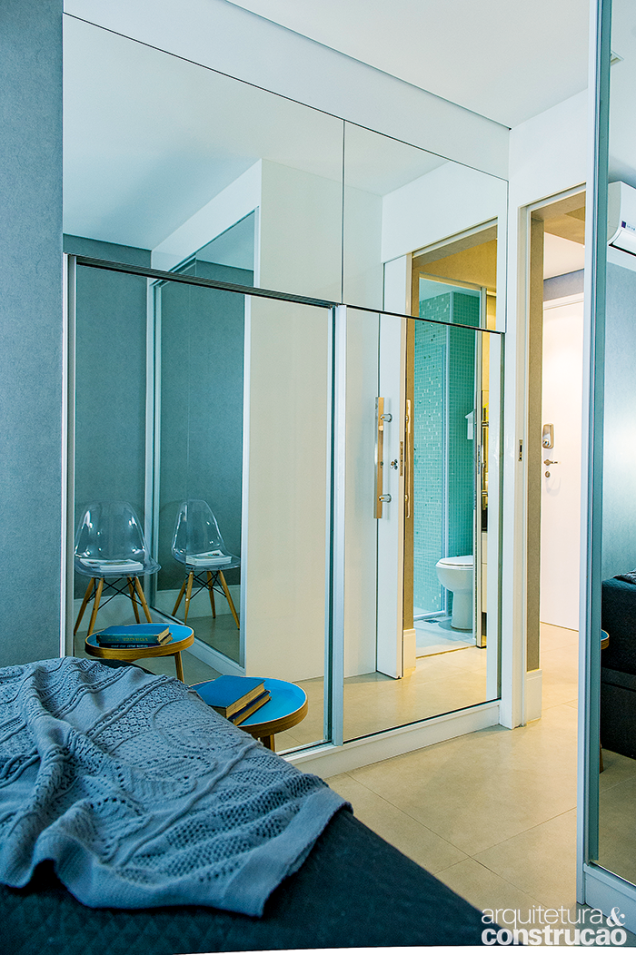 Com 1,78 m de largura total, o armário com portas de correr cobertas de espelho de cima a baixo cumpre o papel de divisória no único dormitório.