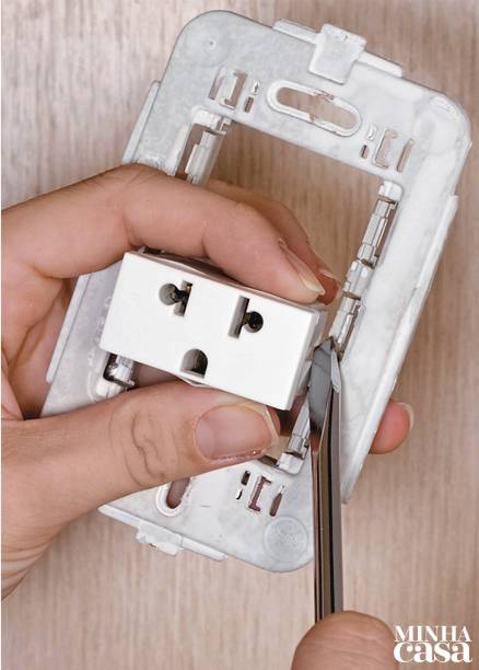 4. Desprenda o módulo de tomada do suporte usando a chave de fenda.