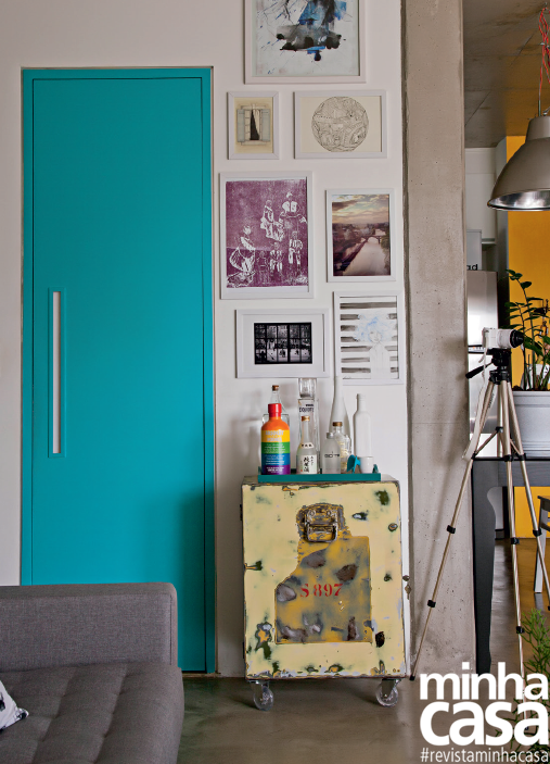 A porta do único banheiro do apartamento foi destacada pela pintura turquesa