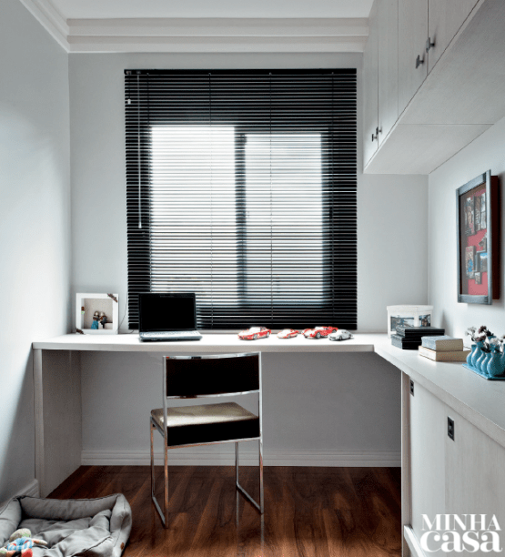 Na planta original, este espaço era destinado a mais um dormitório, porém o casal preferiu integrá-lo ao estar, ampliando a ala social. O dente que ficou próximo à janela virou escritório: uma mesa e uma cadeira deram conta do recado – repare que a bancada é extensão do móvel que apoia a TV.