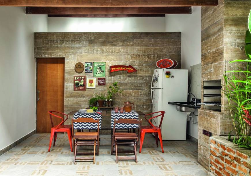 Na porção coberta do quintal acomodou-se um espaço gourmet, com direito a mesa, pia, geladeira e churrasqueira – o modelo pré-moldado foi fechado com drywall do tipo RF (resistente ao fogo). Porcelanatos cobrem todas as superfícies: no piso, foi aplicado o Duo, da Eliane; nas paredes, a escolha recaiu sobre Ibirapuera Patina, da Portobello (Leroy Merlin).