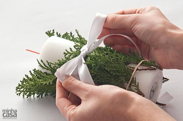 2. No centro, amarre a fita branca finalizando com um laço – evite apertá-lo com muita força para que as plantas não se quebrem. Apare as pontas da fita com a tesoura e retire o elástico. 2. No centro, amarre a fita branca finalizando com um laço – evite apertá-lo com muita força para que as plantas não se quebrem. Apare as pontas da fita com a tesoura e retire o elástico.
