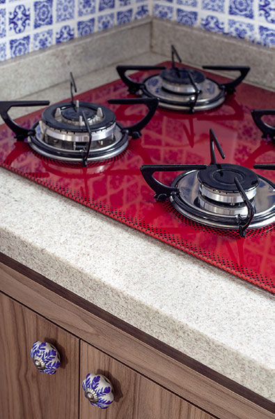  O cooktop e o pendente vermelhos contrastam com o  azul predominante e ajudam a aquecer o visual do ambiente