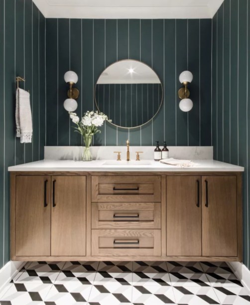13-31-banheiros-que-incorporam-o-glamour-do-art-deco Combine listras com paralelogramos – O estilo Art Déco é conhecido por sua geometria nítida, mas não se limite a formas clássicas como círculos, quadrados e ovais. Lembre-se de que formas menos óbvias, como trapézios e paralelogramos, podem ser igualmente divertidas de brincar. E estampas marcantes, como listras e bolinhas, podem ser outra maneira de trazer formas para o seu espaço.
