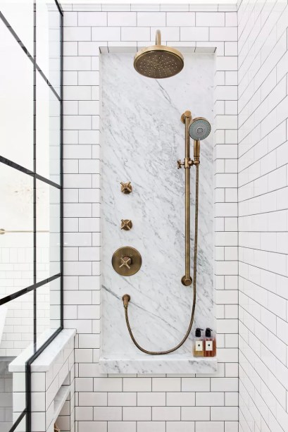 14-31-banheiros-que-incorporam-o-glamour-do-art-deco Coloque um revestimento de mármore em seu chuveiro – Poucas coisas são tão Art Deco quanto incrustações de mármore em um chuveiro. Por quê? O mármore é um material luxuoso que homenageia o glamour da época. E, dependendo da maneira como você estrutura seu embutimento, você também pode fazer referência às linhas elegantes e formas escalonadas do Art Déco.