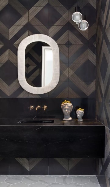 26-31-banheiros-que-incorporam-o-glamour-do-art-deco Crie um padrão de parede a parede – Quando muitos de nós vamos decorar nossas paredes, optamos por opções clássicas, como tinta ou papel de parede. Mas quando você está lidando com um banheiro, você pode facilmente revestir suas paredes com azulejos. Para criar mais impacto visual, considere escolher um conjunto de azulejos padronizados – ou opte por ladrilhos que criam um padrão de parede a parede quando combinados.