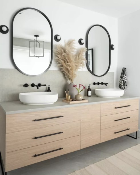 28-31-banheiros-que-incorporam-o-glamour-do-art-deco Mantenha as coisas simétricas – Na dúvida, procure maneiras de adicionar simetria, pois é fácil de obter. E se você fizer isso obviamente o suficiente, será um aceno para Art Déco, mesmo se você misturou outras estéticas em seu espaço.Mas como fazer isso? Trabalhe em duplas. Divida um grande espelho de parede em dois espelhos menores iguais, em seguida, combine esses espelhos com pias e armários. Se você realmente deseja enfatizar seu ponto de vista, adicione ainda mais pares simétricos. Pendure luzes pendentes correspondentes em cada lado de cada espelho ou flanqueie cada espelho com um par de arandelas iguais.